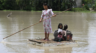 Children paddle through flood waters